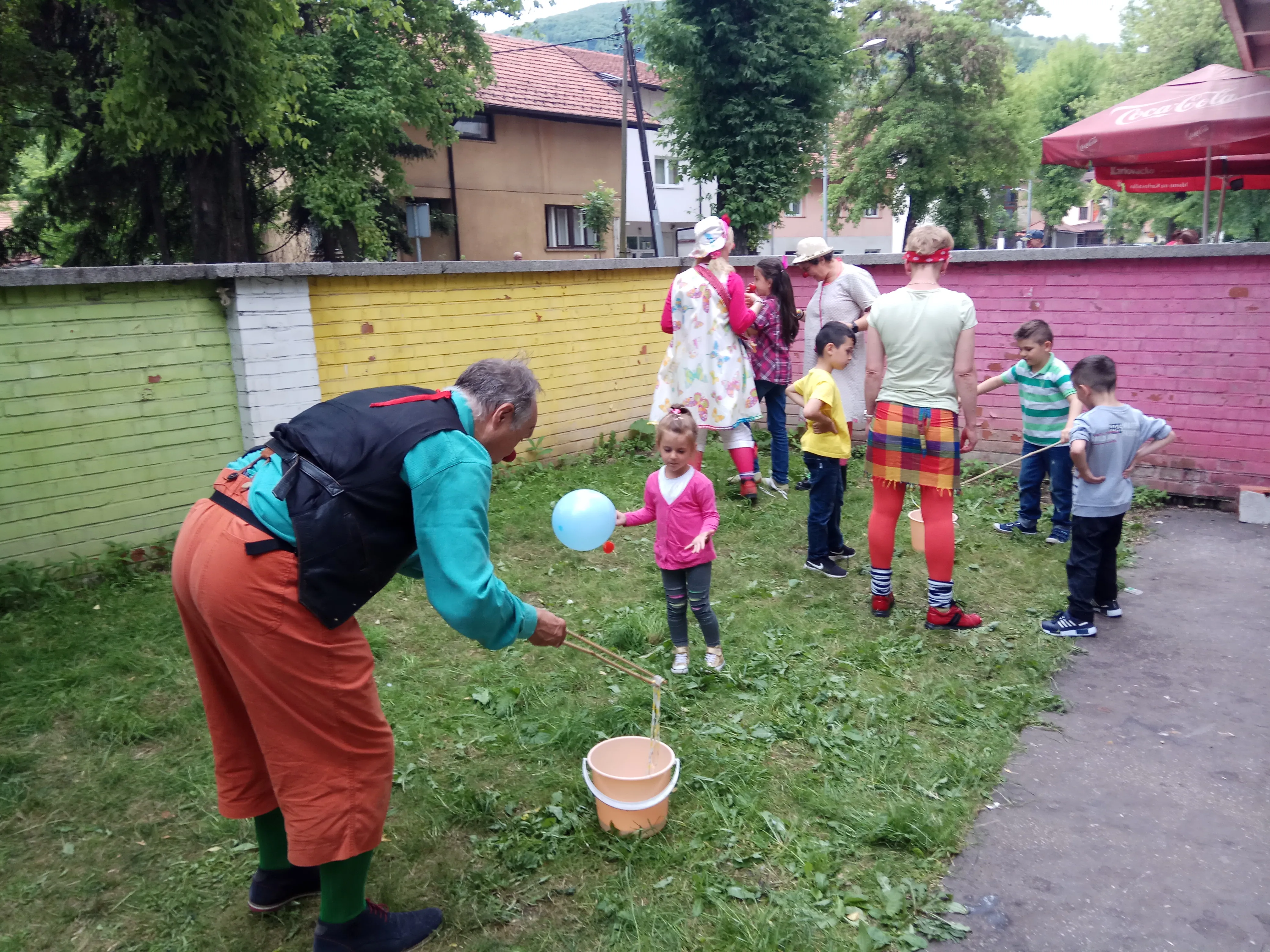 Children playing a balloon game with a volunteer at the day center