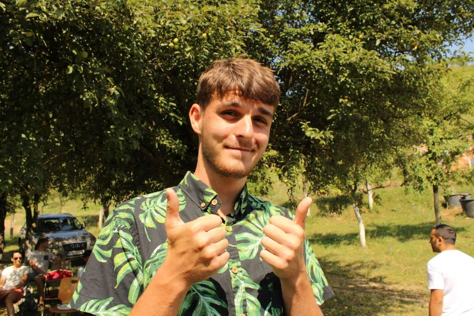 Nermin, who came up through the work, giving two thumbs up in the orchard at Grace Valley